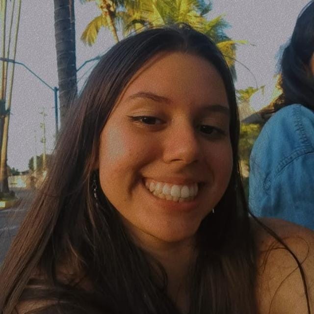 Foto da Integrante Bianca Schiavo, ela está ao ar livre, tem cabelo liso castanho escuro.